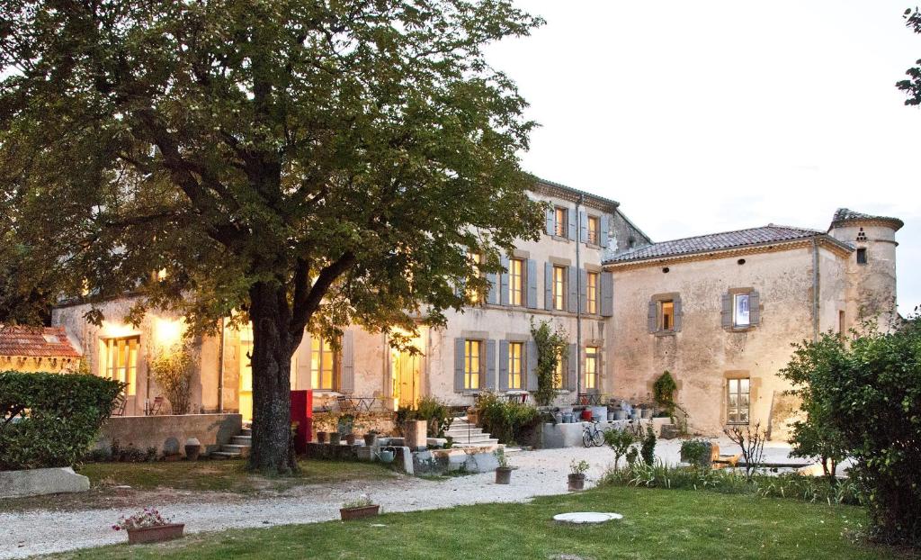 La Grande Maison في Montmeyran: مبنى كبير امامه شجرة