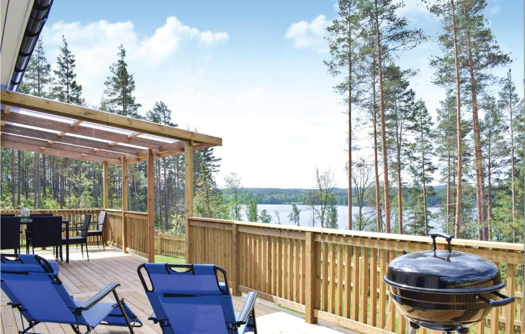 um deque com cadeiras e um grelhador com vista para um lago em Beautiful Home In Mlilla With Kitchen em Bäckeby