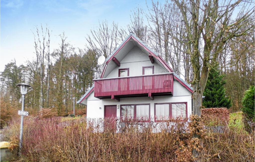 uma casa com uma varanda vermelha em cima em Ferienhaus 70 In Kirchheim em Kemmerode