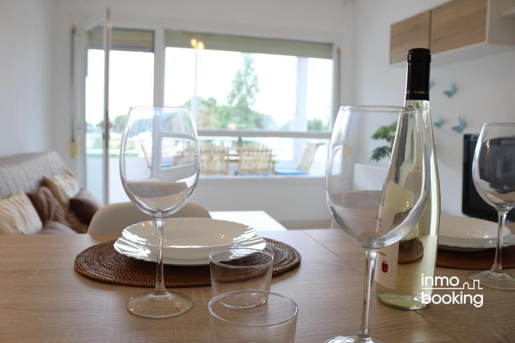 カンブリルスにあるInmoBooking Tahity Apartmentのワイングラス2杯とワイン1本付きのテーブル