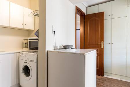a kitchen with a washing machine and a washer at Irodotou Studio in Thessaloniki