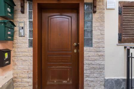 a wooden door in a building with a brick wall at Irodotou Studio in Thessaloniki