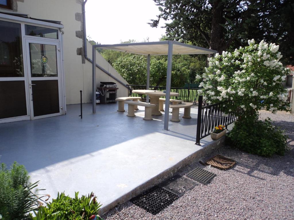 a patio with a table and an umbrella at Gîte La Lieutenance in Saint-Pourçain-sur-Sioule