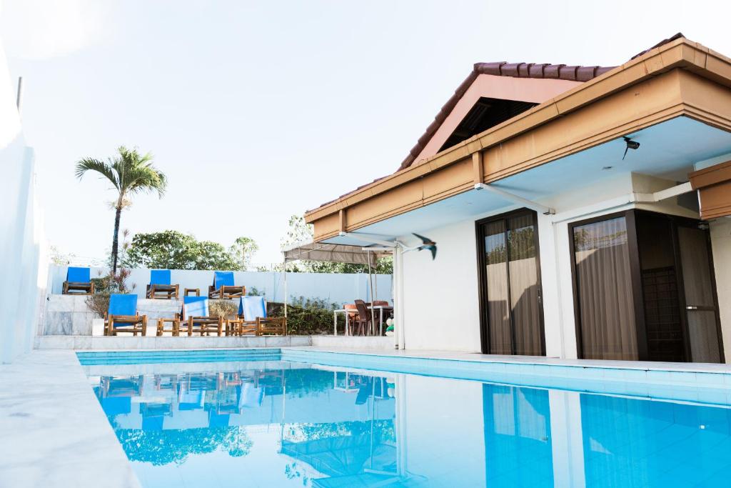 une villa avec une piscine et une maison dans l'établissement Backpackers Place in SEAVIEWHILLS BOHOL, à Panglao