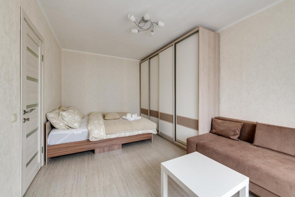 una pequeña sala de estar con sofá y cama en Cosy apartment with two bedrooms on Khersonskaya street en Moscú