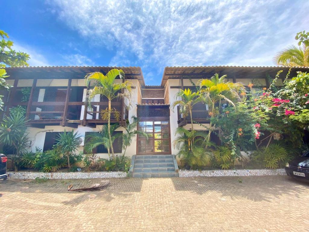 una casa con palmeras delante en Hotel - Pousada-Zen Bougainville, en Salvador