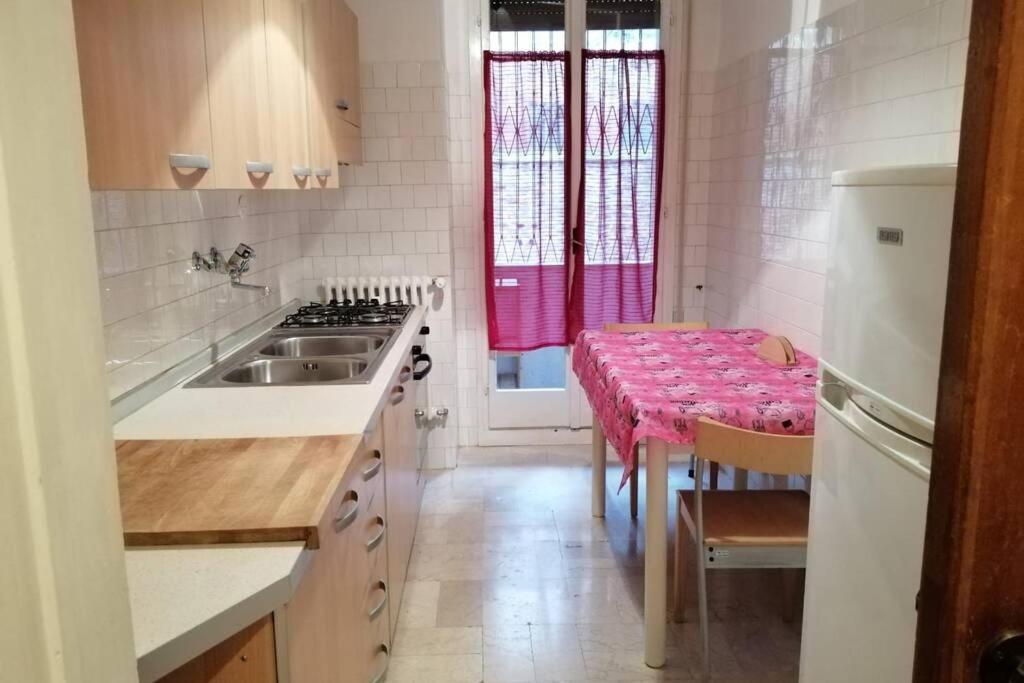 une cuisine avec un évier et une table avec un tissu de table rose dans l'établissement Casa 96F, à Venise