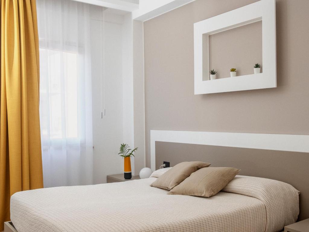 1 dormitorio con cama con espejo y cortinas amarillas en Liolá Cefalù, en Cefalú