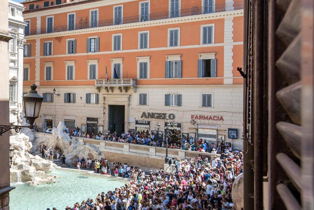 een menigte mensen die voor een gebouw staan bij La Finestra su Fontana di Trevi - Charming View in Rome