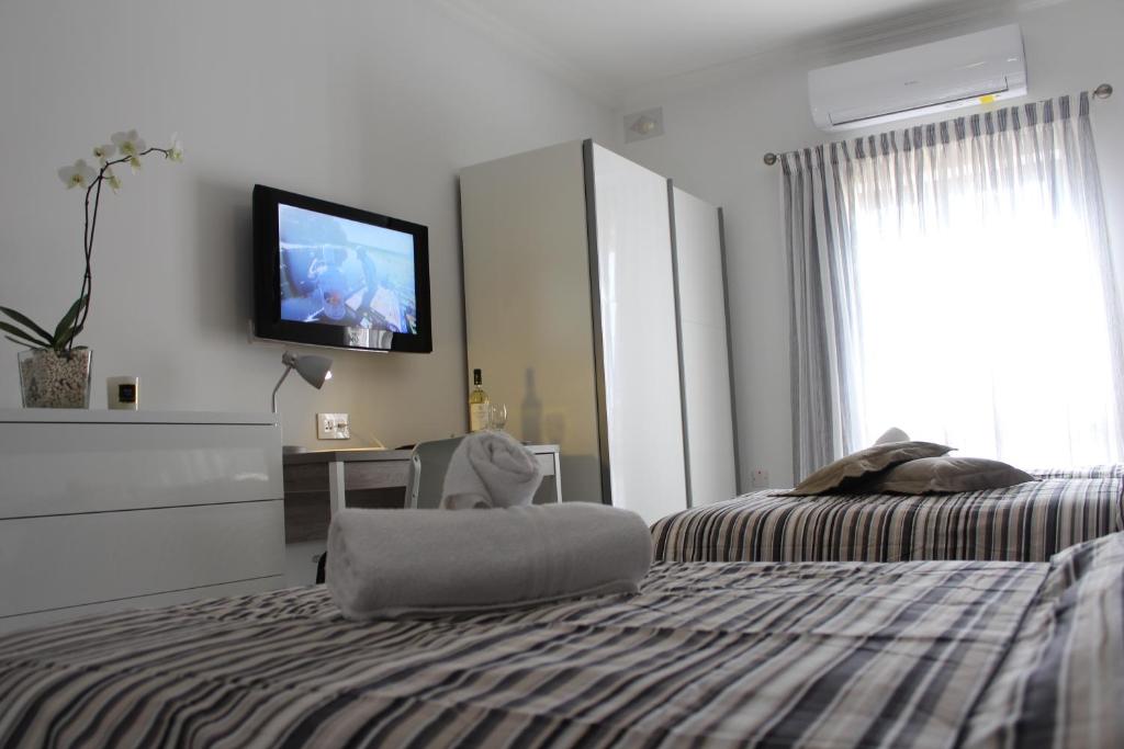 a bedroom with a bed and a tv on the wall at Cosy Home in Mellieħa