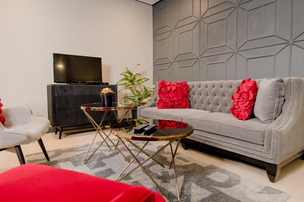 a living room with a couch and red pillows at Sta Barbara Residence Hotel in Cebu City