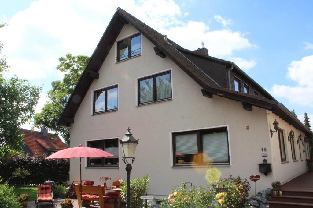 a white house with windows and an umbrella at Haus Hanseatic Ferienwohnungen in Bad Harzburg