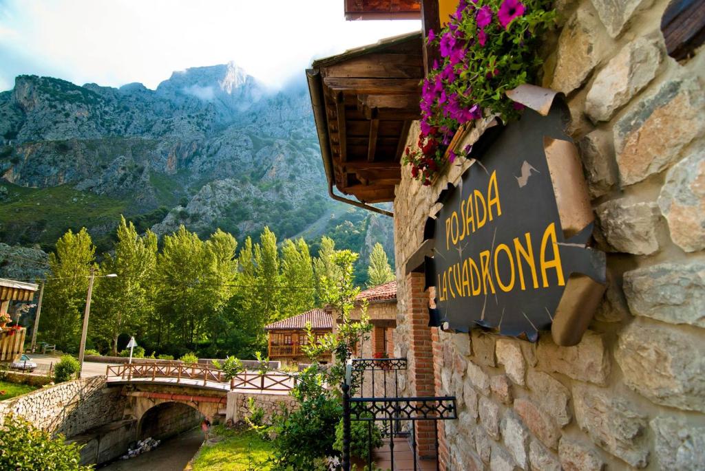 ein Schild für ein Restaurant an der Seite eines Gebäudes in der Unterkunft Posada La Cuadrona in La Hermida