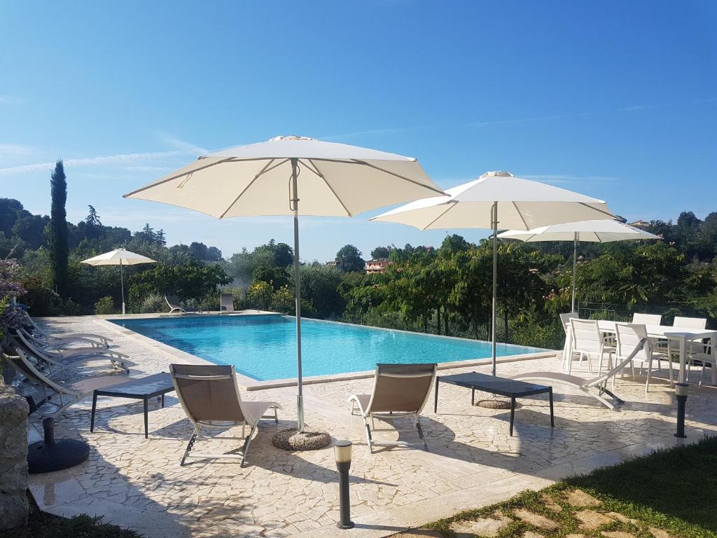 een groep stoelen en parasols naast een zwembad bij Villa Primavera in Stimigliano