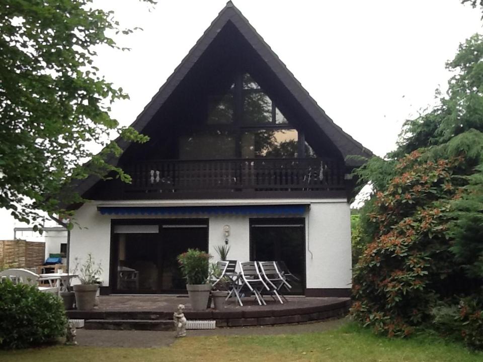 ein Haus mit 2 Stühlen und einem Balkon in der Unterkunft Appartement in der Waldsiedlung in Leverkusen