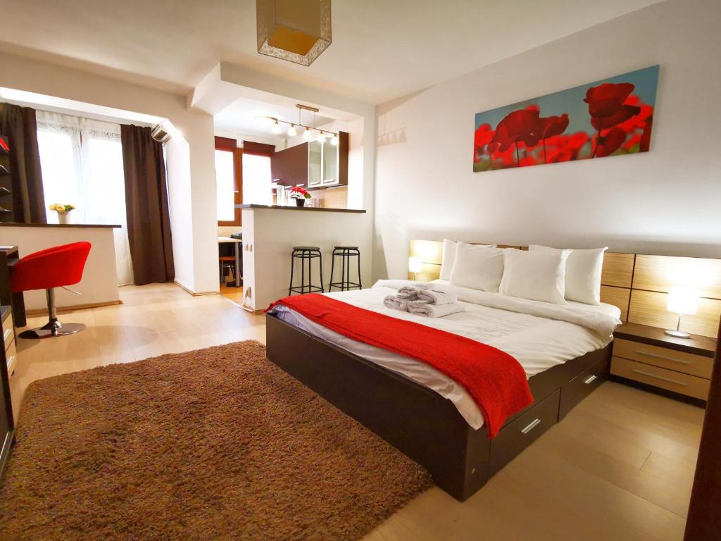 1 dormitorio con 1 cama grande con manta roja en Dristor - Studio D by MRG Apartments en Bucarest