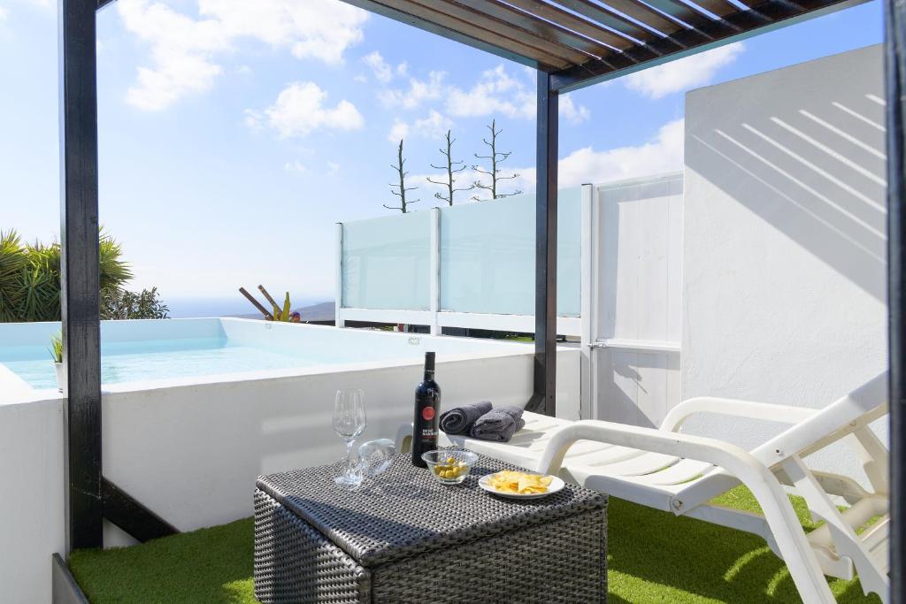 a patio with a table with a bottle of wine at Casa Amanecer in Tías