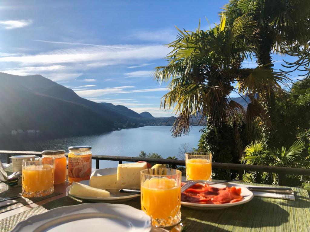 einen Tisch mit einem Teller mit Lebensmitteln und Orangensaft in der Unterkunft Casa al Sole in Morcote