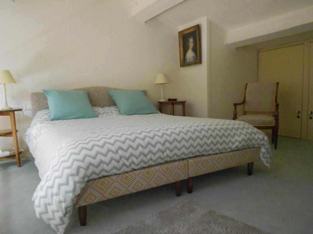 ein Schlafzimmer mit einem großen Bett und einem Stuhl in der Unterkunft Maison de Pêcheur in Toulon