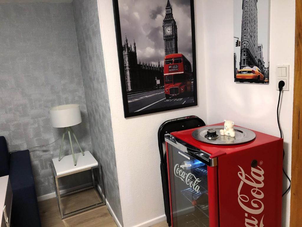 a coca cola machine in a room with a picture of big ben at &quot;An der Lindenberganlage&quot; in Melsungen