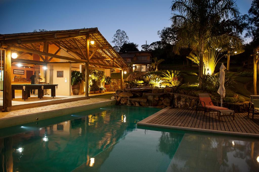 a swimming pool in a backyard with a picnic table at Pousada Ecológica Espelho D'Água in Carrancas