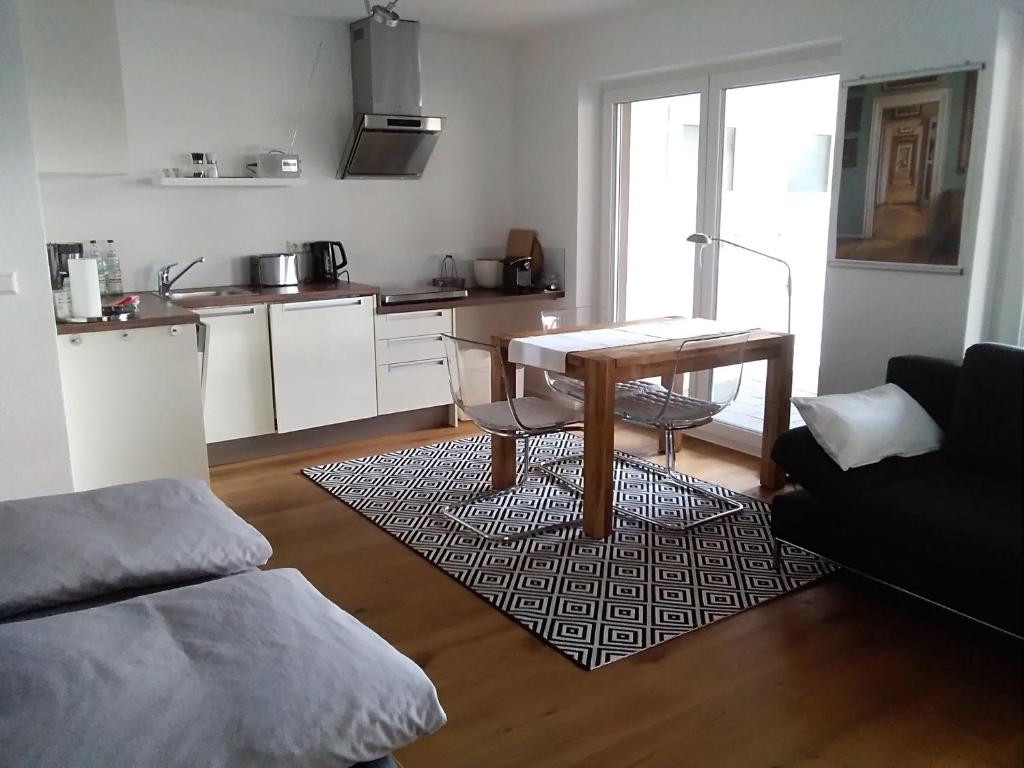 a living room with a table and a kitchen at Ferienwohnung im Weinbergweg in Ravensburg