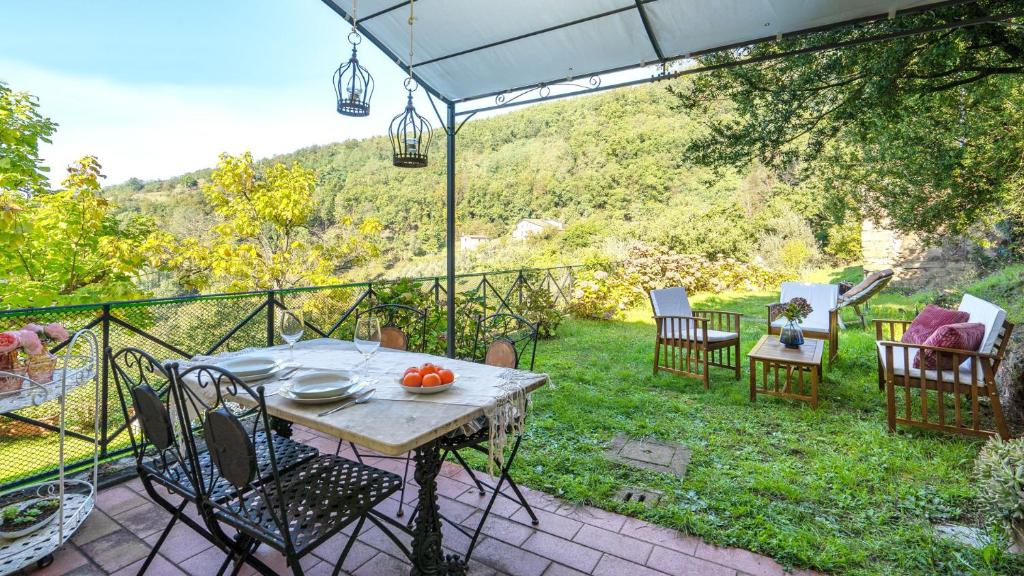 a patio with a table and chairs and an umbrella at Gabriella's Romantic Cottage in Pistoia