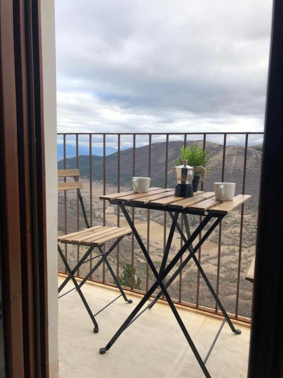a table and chairs on a balcony with a view at Casa Antica in Santo Stefano di Sessanio
