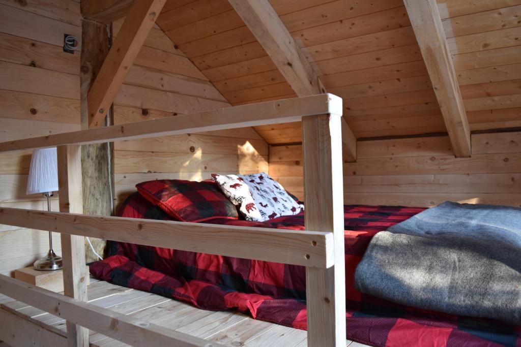 um quarto num chalé de madeira com um beliche em Bois Rond Expérience em Saguenay
