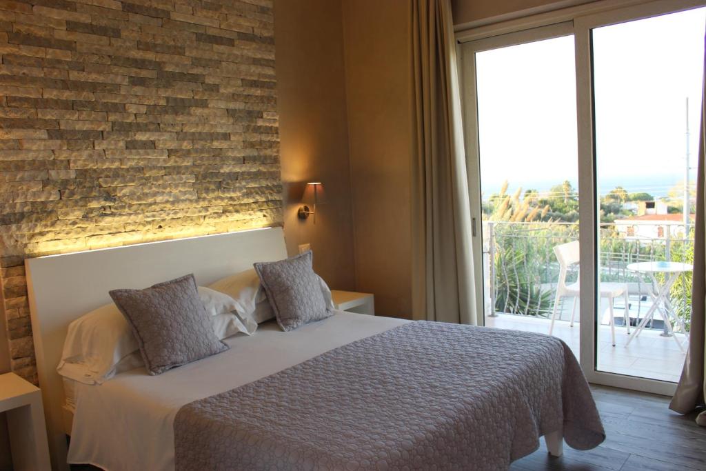 a bedroom with a bed with a brick wall at Borgo di Santa Barbara in Santa Domenica