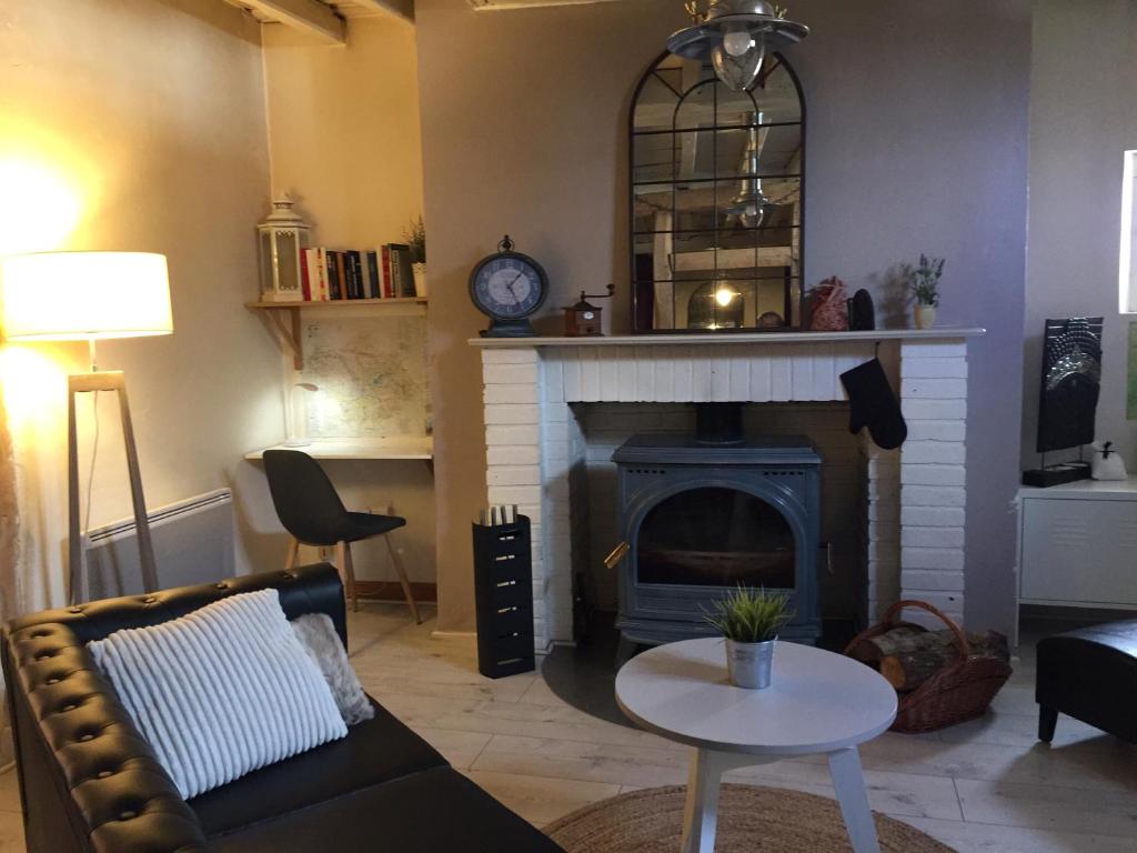 a living room with a couch and a fireplace at Maison IZARO in Précy-Saint-Martin