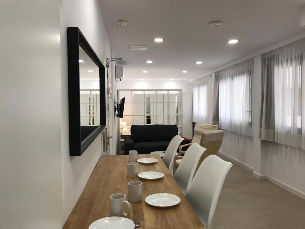 a living room with a wooden table and white chairs at Bet Apartments - Reig in Valencia