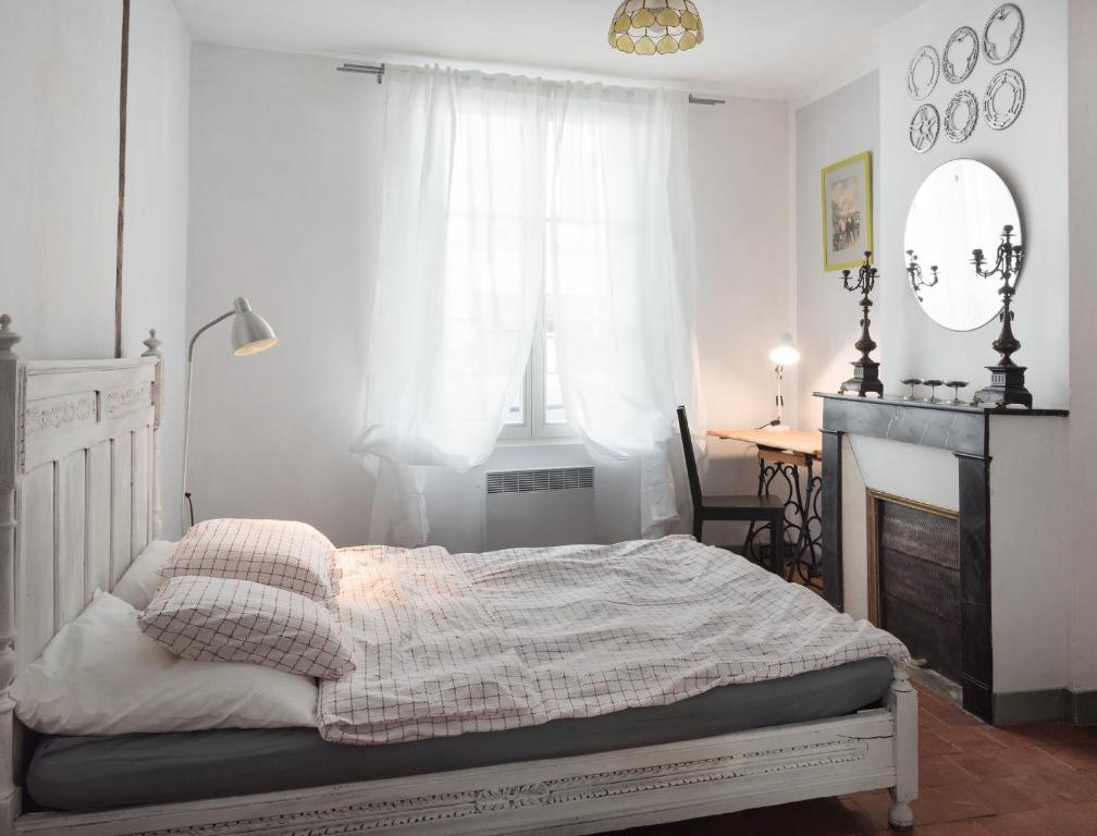 une chambre blanche avec un lit et une cheminée dans l'établissement Tour de France historique et châteaux de Loire, à Orléans