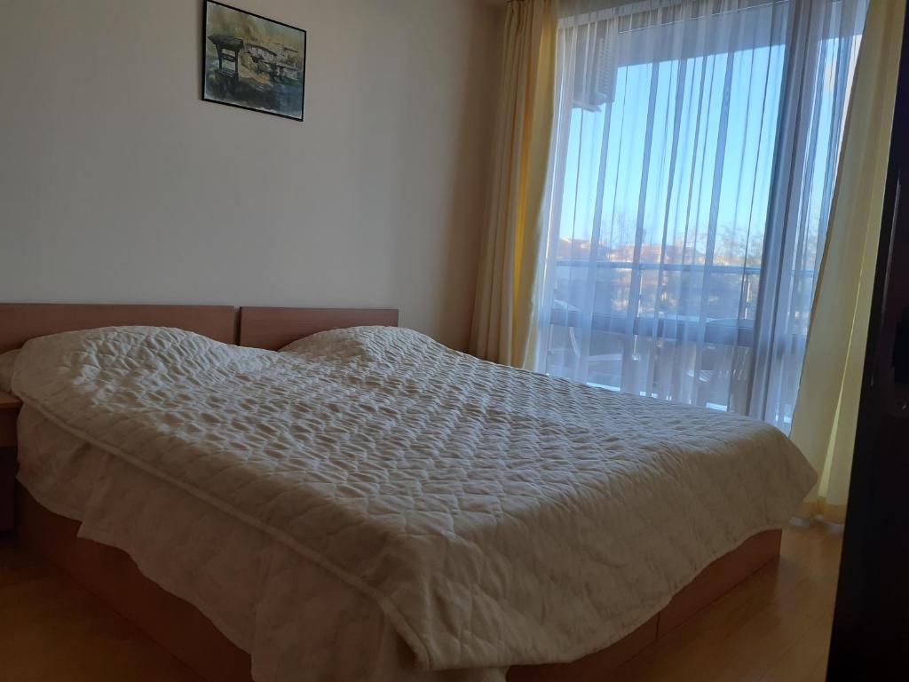 a bedroom with a bed and a large window at Panorama Vigo Nesebar in Nesebar