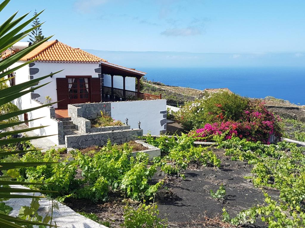 una casa con un jardín con el océano en el fondo en Casa las Las Viñas, en Fuencaliente de la Palma