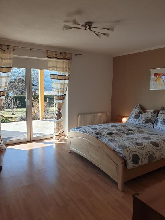 a bedroom with a bed and a sliding glass door at Ferienwohnung Albert Egger in Nötsch