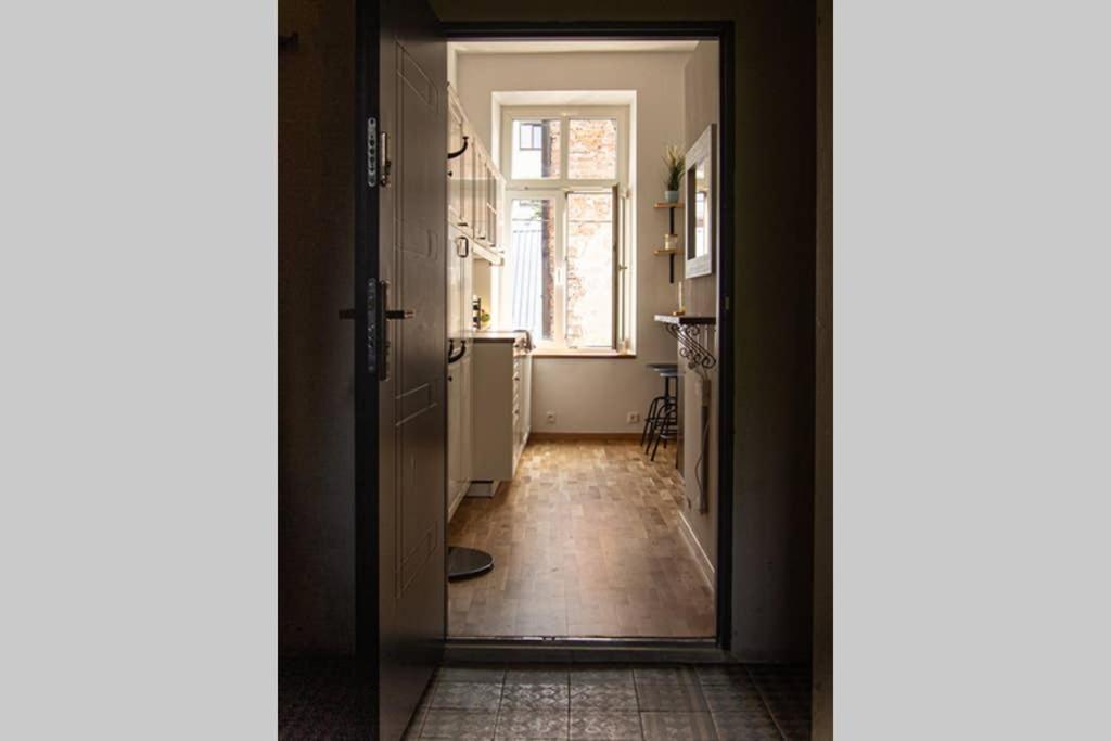 a hallway with a door leading to a kitchen with a window at O & O Studio in Kraków