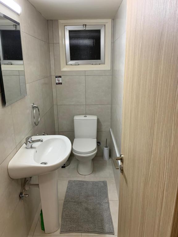 La salle de bains est pourvue d'un lavabo, de toilettes et d'une fenêtre. dans l'établissement Tony’s Boutique Apartment, à Larnaka