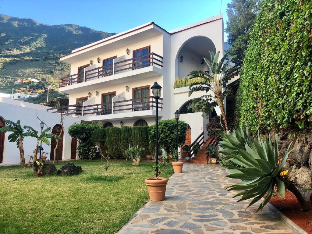 a large white building with potted plants in front of it at Apartamentos Frontera in Frontera