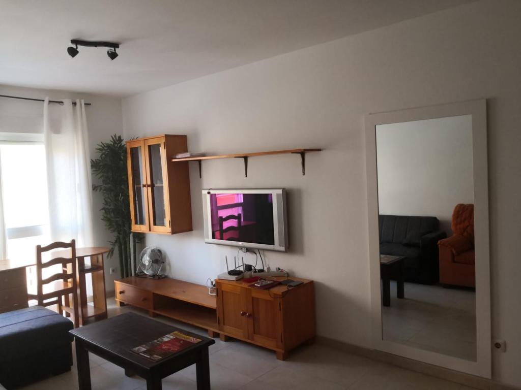 sala de estar con TV en la pared en Vv Hoony Mugler wifi free private parking aire acondiciony, en Puerto del Rosario