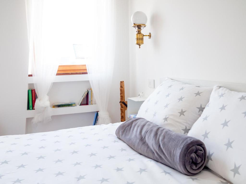 a bedroom with a bed with gray and white pillows at B&B marnaecalcare in Sedico