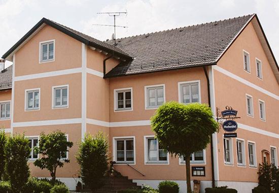 um grande edifício laranja e branco com um telhado preto em Gasthof Krone Ochsenfeld em Ochsenfeld