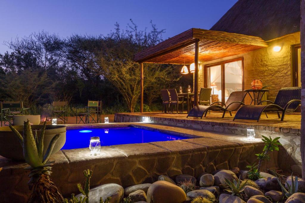 - une piscine dans un jardin la nuit dans l'établissement Zebra Lodge & Giraffe Lodge, à Hoedspruit