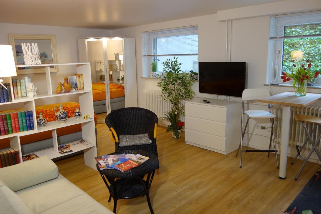 a living room with a table and a desk with a television at Erftmündung in Neuss