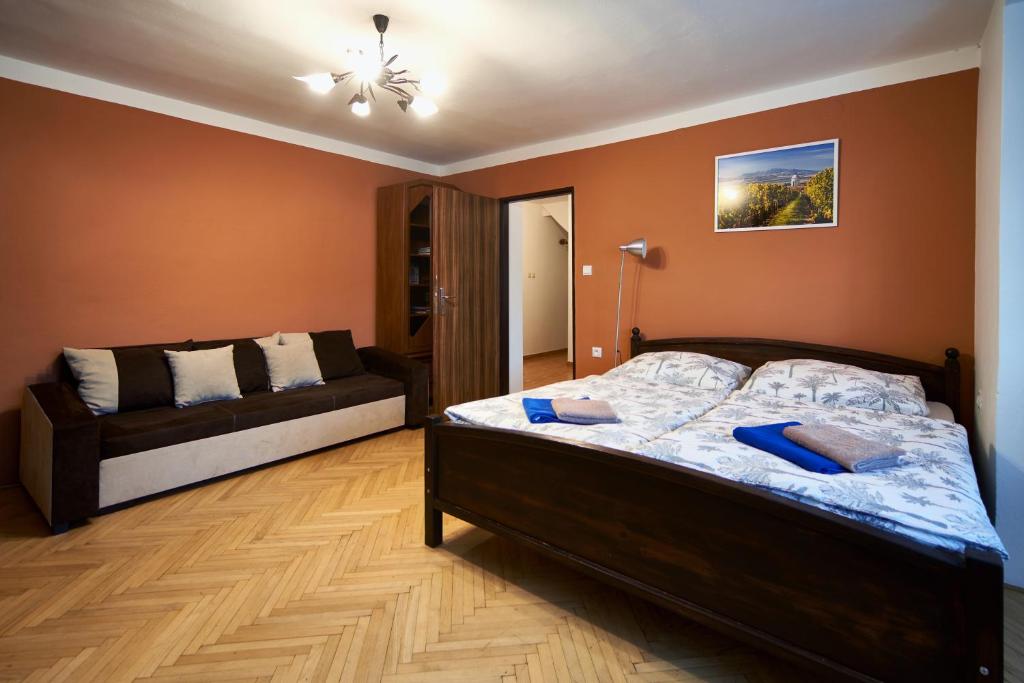 1 dormitorio con cama y sofá en Penzion Zajíček, en Zaječí