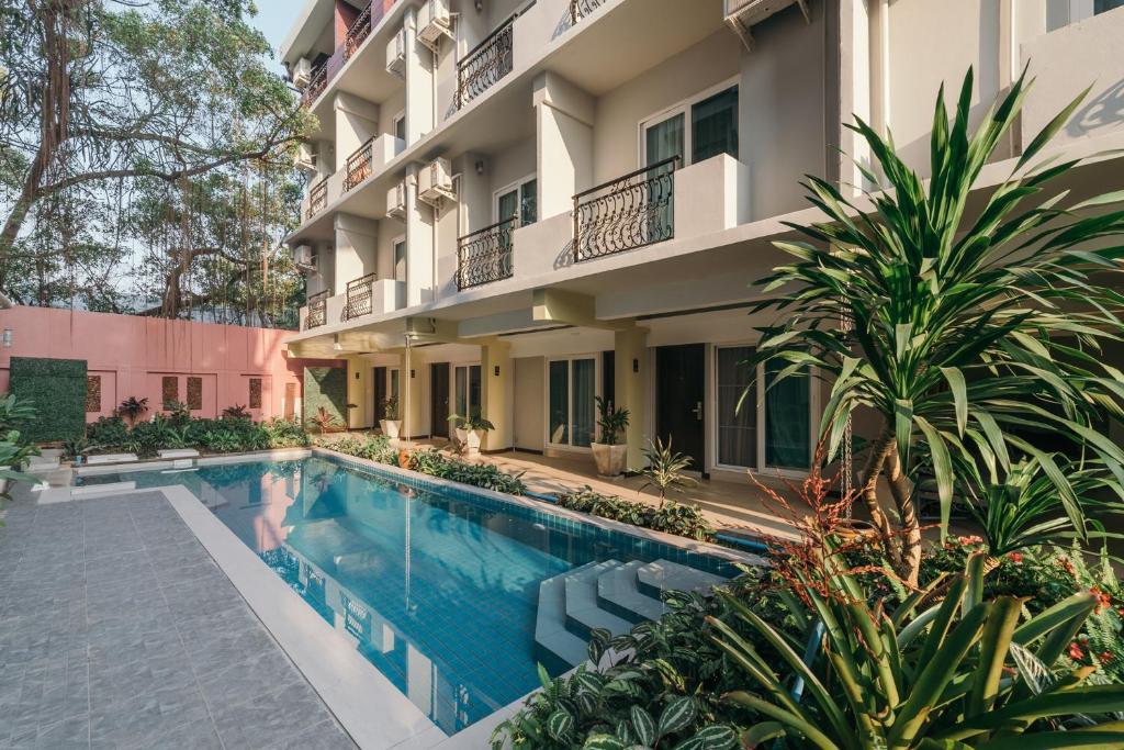 a swimming pool in front of a building at Cozytel Chiangmai in Chiang Mai