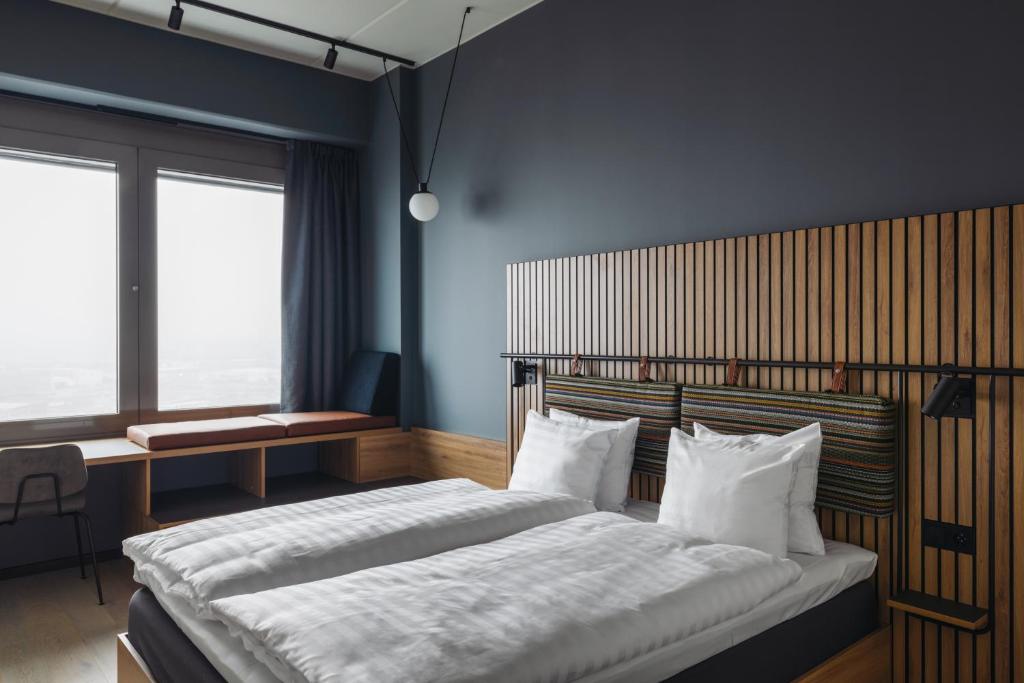 um quarto com uma cama grande com lençóis e travesseiros brancos em Comfort Hotel Arlanda Airport Terminal em Arlanda