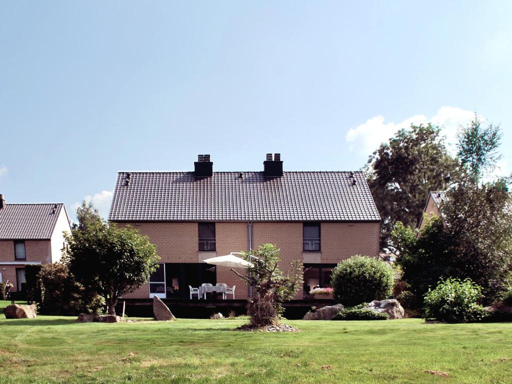 uma casa grande com um relvado em frente em B&B Le Clos du Lac em Sart-lez-Spa