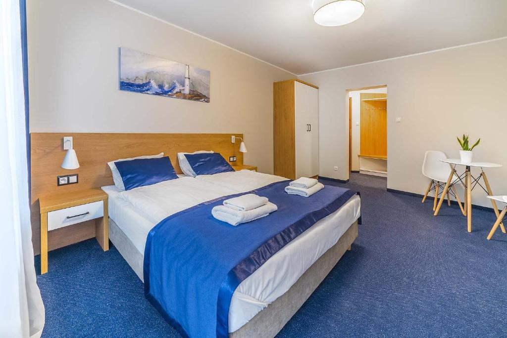 Habitación de hotel con cama grande con sábanas azules en Navii en Władysławowo