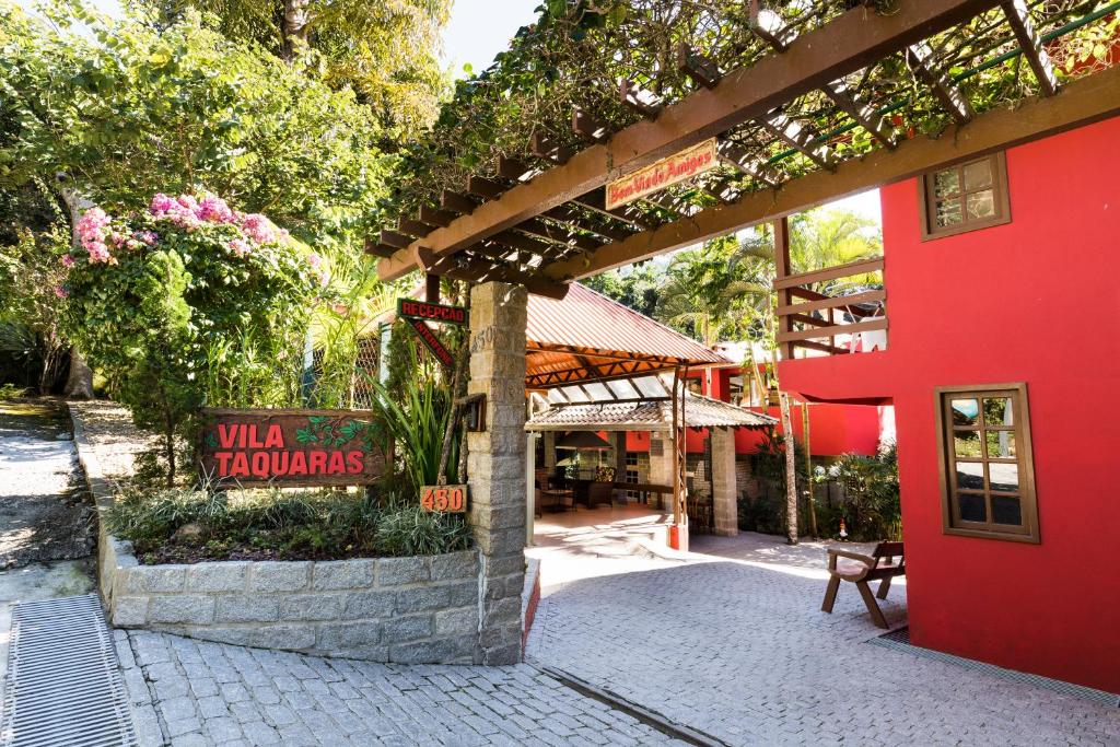 een rood gebouw met een bord voor een restaurant bij Pousada Vila Taquaras in Balneário Camboriú